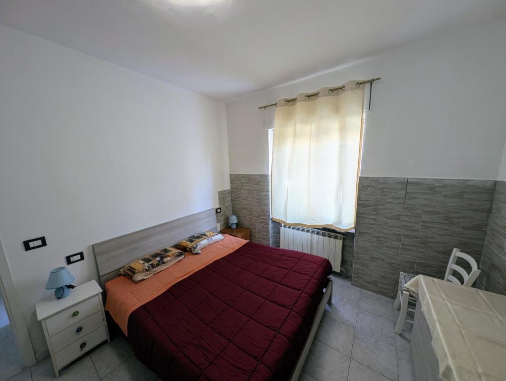 a bedroom with a red bed and a window at Casa del Coro in Perugia