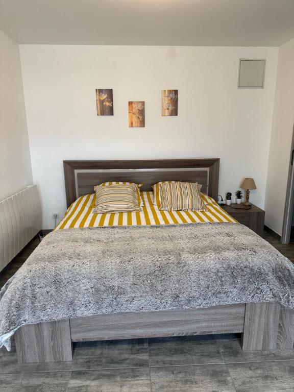 a bedroom with a large bed with yellow and orange stripes at BOUTON D'OR Studio Terrasse Grand Lit Coin Repas in Château-Arnoux-Saint-Auban