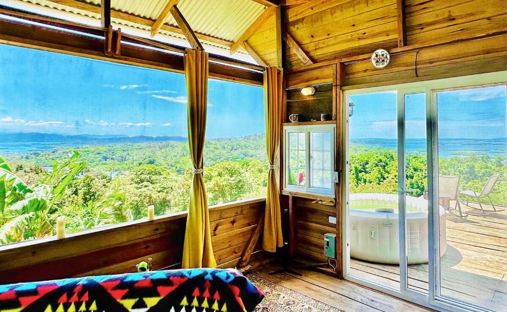 a bedroom with a tub and a large window at Mountain Chalet with Awesome Sea View in Loma Partida