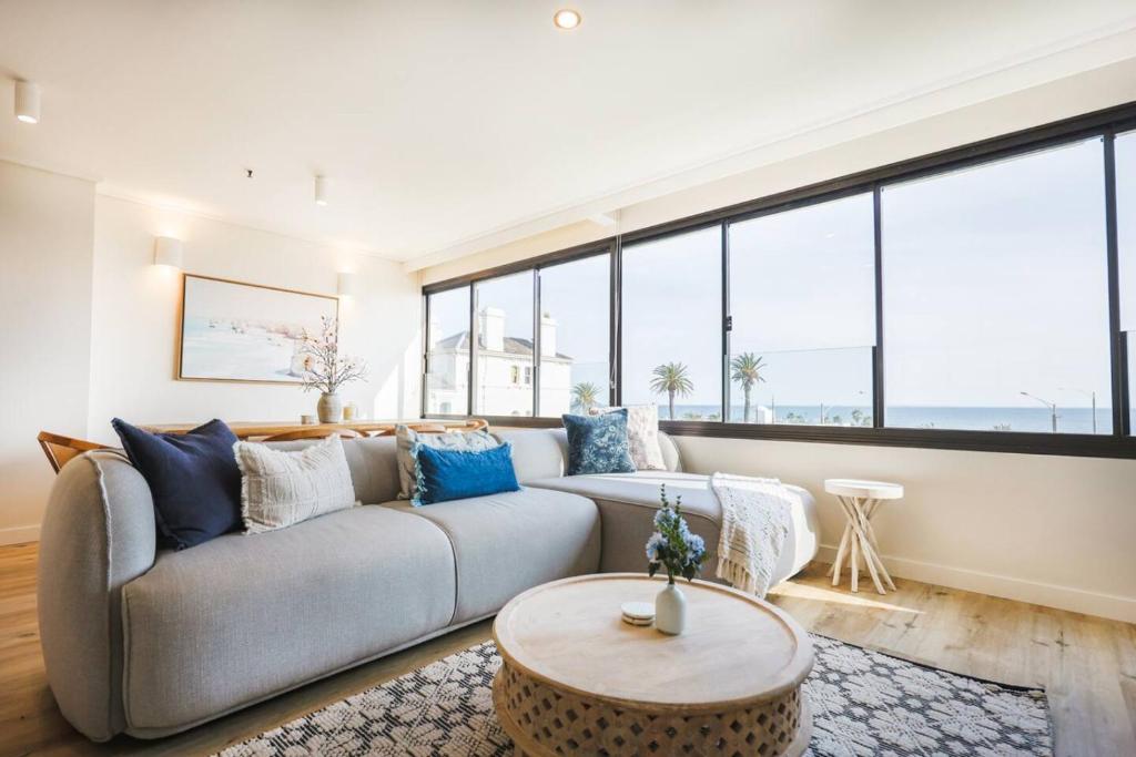 a living room with a couch and large windows at Luxury Beach View Escape in Melbourne