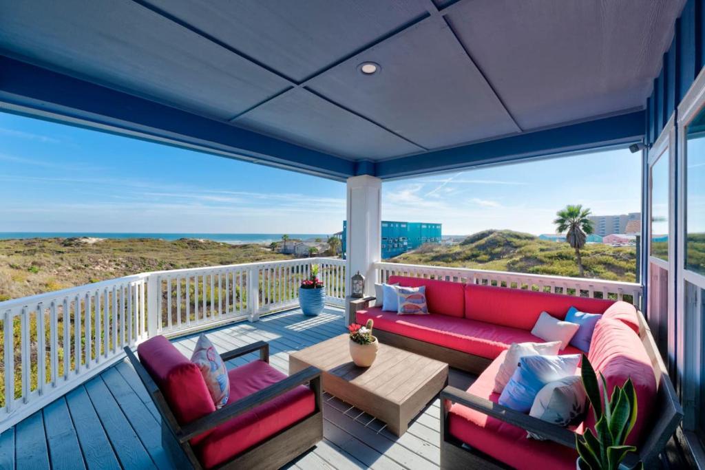 a porch with a couch and a table on a balcony at Horizon House Stay. Relax. Repeat. in Port Aransas