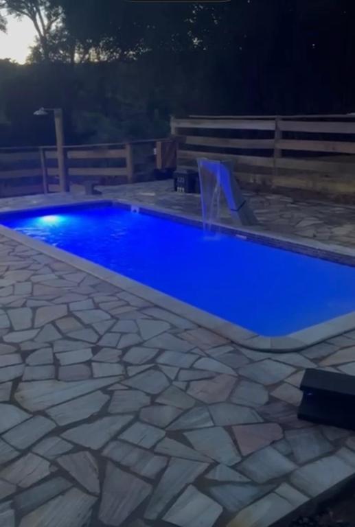 a blue swimming pool with a water fountain at Toca do sonic in CÃ¡ssia