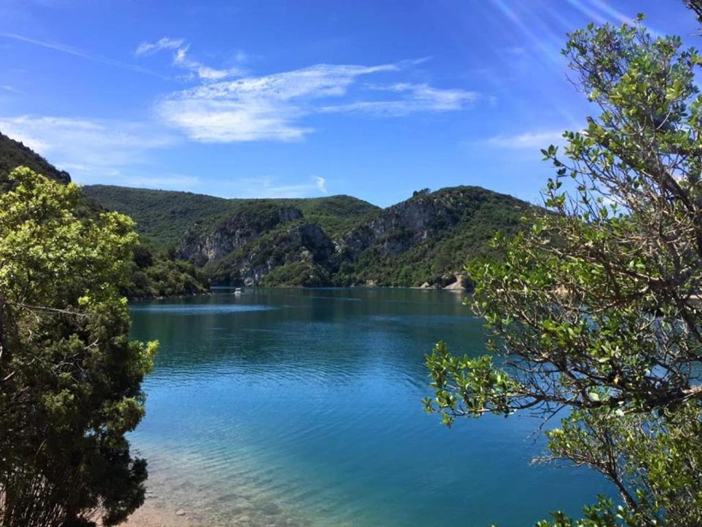 a view of a lake with mountains in the background at Camping Verdon familial 3 étoiles - 20 min du lac de Sainte Croix in Esparron-de-Verdon