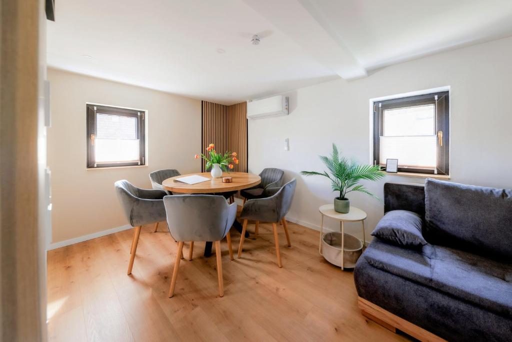 a living room with a table and a couch at CASA BENJI - Familienfreundliche FeWo - Landhausstil - Garten - Parkplatz in Pirna