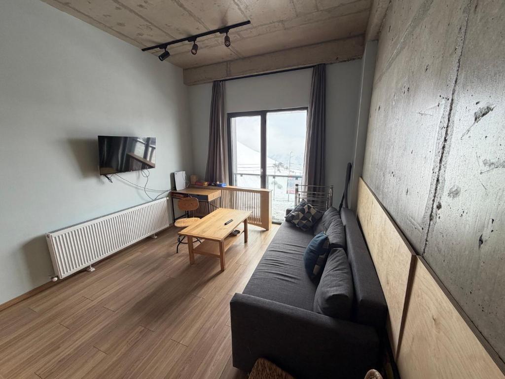 a living room with a couch and a table at Art house in Kʼumlistsʼikhe