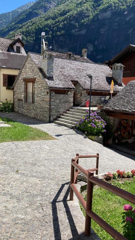a stone building with a bench in front of it at Antico Borgo 2 in Cadarese
