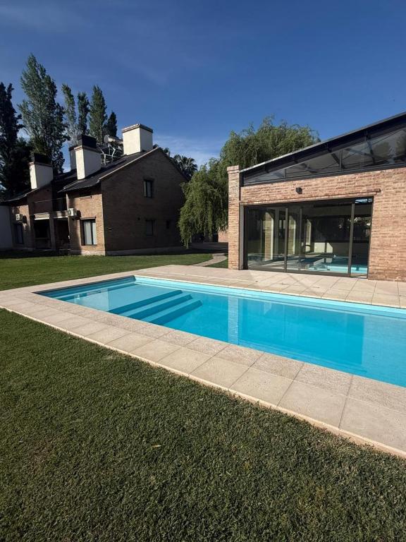 a swimming pool in front of a house at Terroir Village - Complejo en Mendoza in Guaymallen