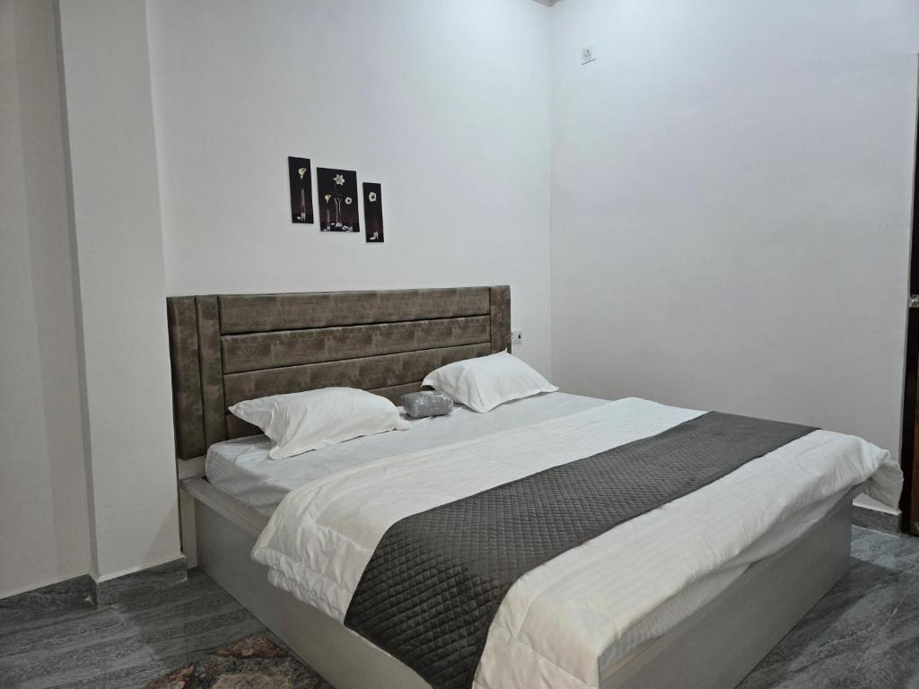 a bedroom with a large bed with white sheets at Arctic Inn in Gorakhpur