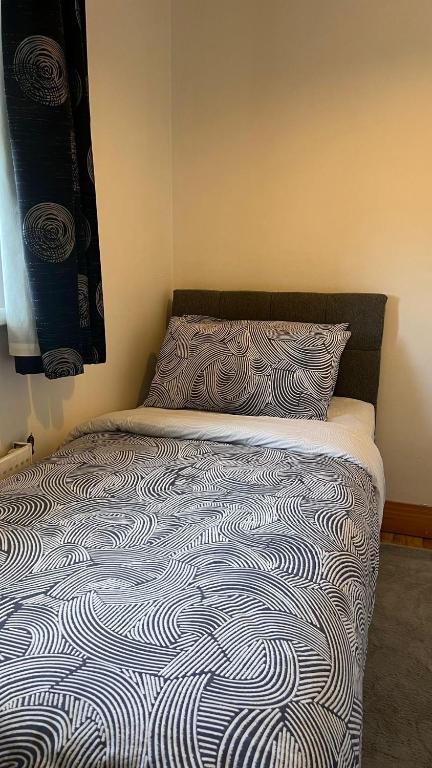 a bed in a bedroom with a blanket and a pillow at 83 Clonmullion Athy county Kildare in Athy