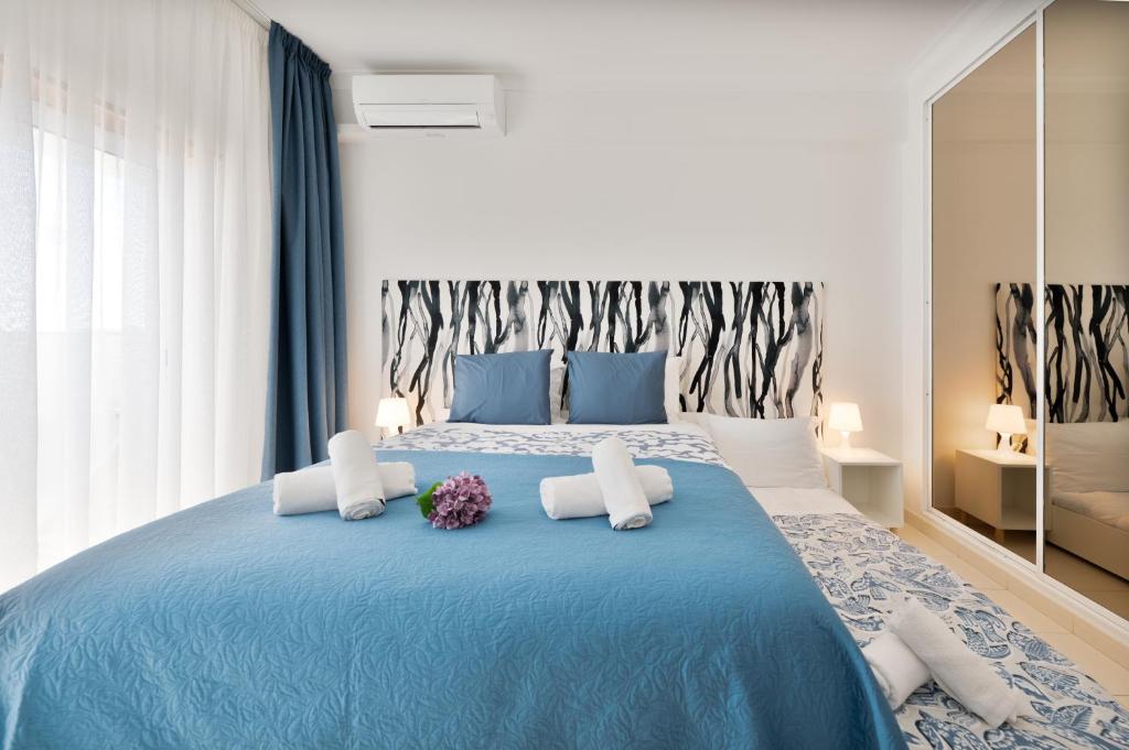 a bedroom with a blue bed with flowers on it at Casa Azul 3 - Senhora da Rocha, Algarve in Porches