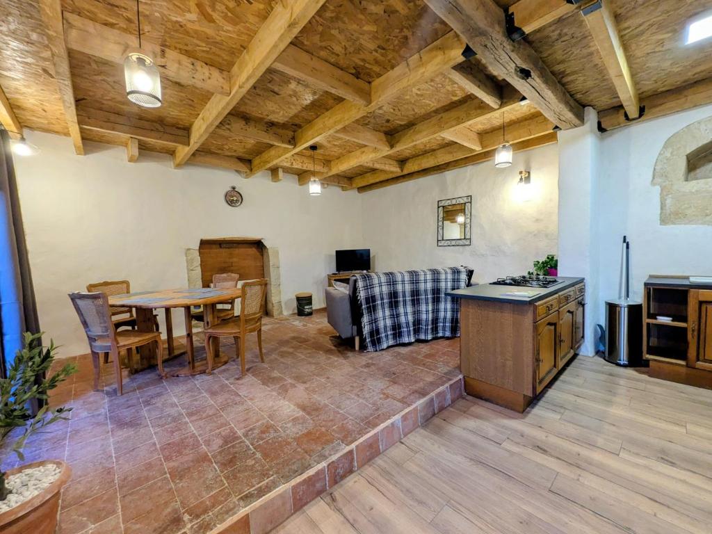 a large living room with a table and a kitchen at Gîte Val de Loire Le Puits in Loudun