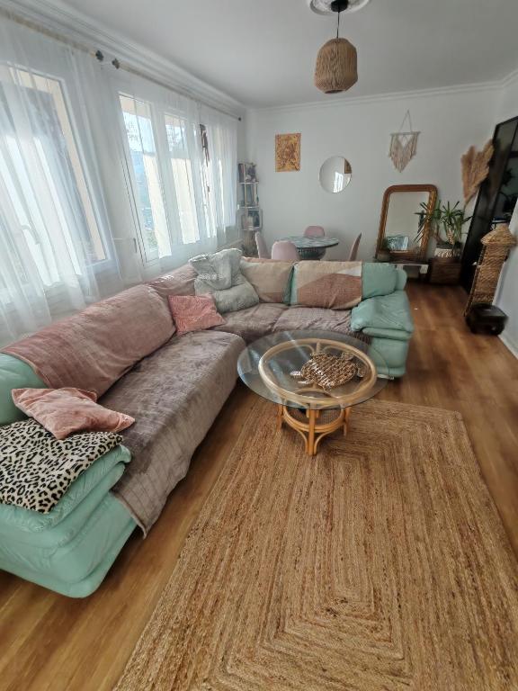 un soggiorno con un divano e un tavolo di Cosy Coty a Tours
