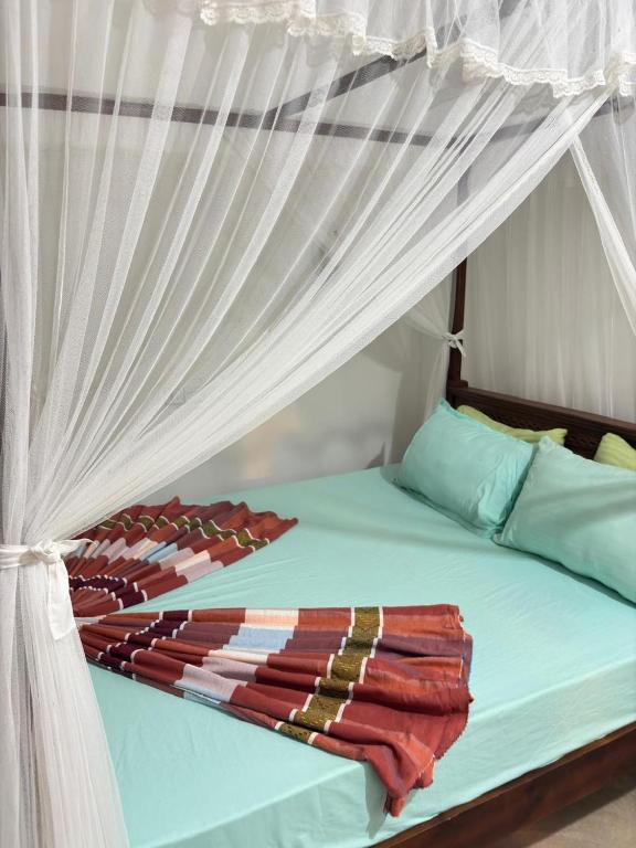 a bedroom with a bed with a white canopy at Fairview Villa in Hikkaduwa