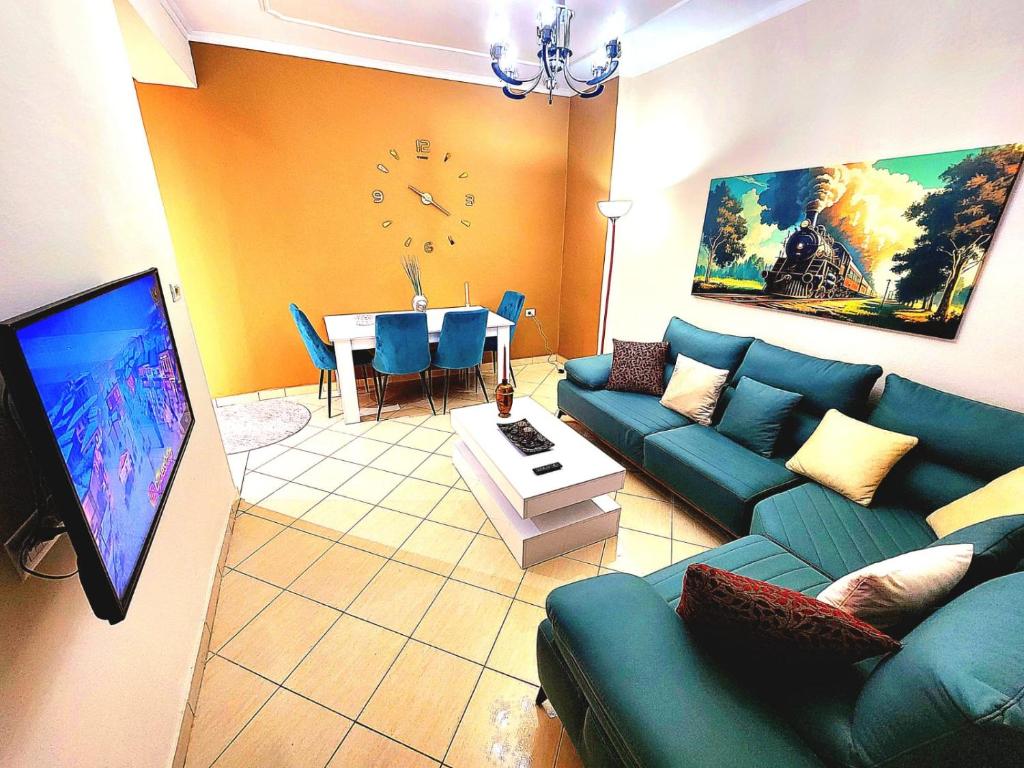 a living room with a blue couch and a table at Apartament me qira ditore "AGA"Fier in Fier