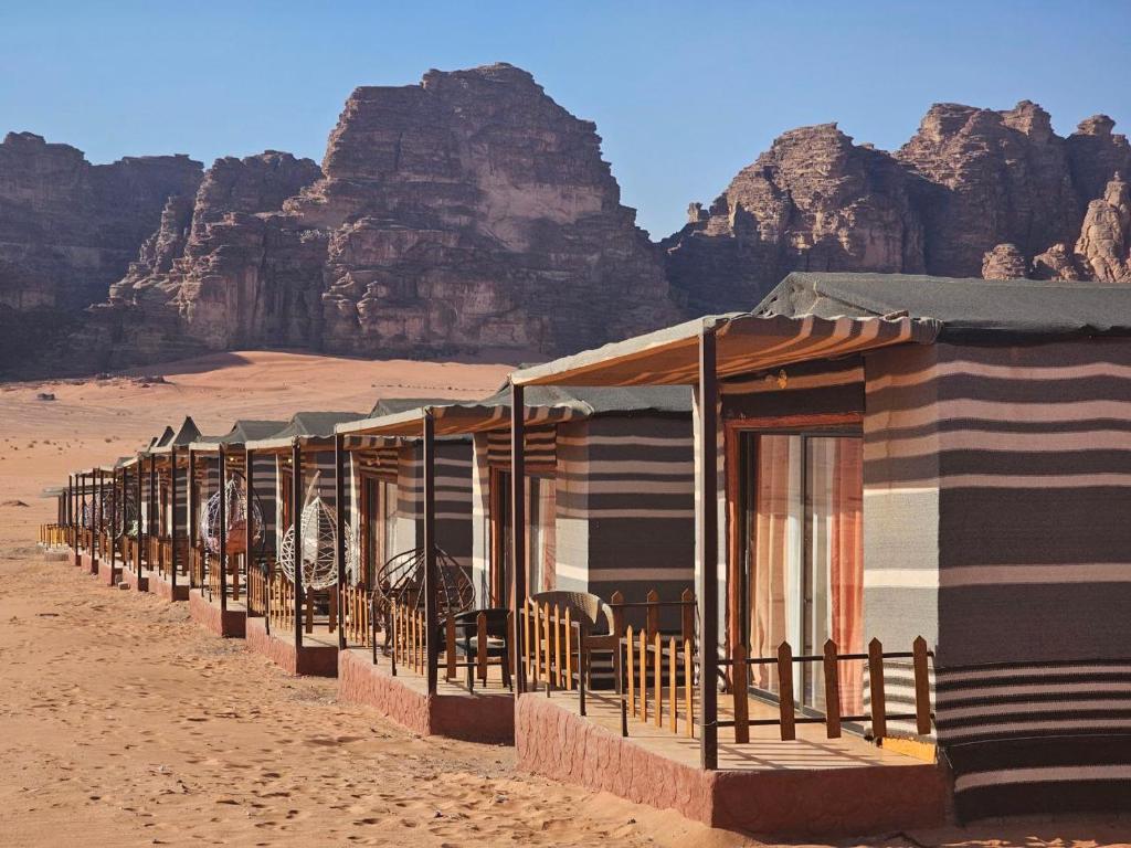 a row of tents in the desert with mountains in the background at Camp sami in Disah