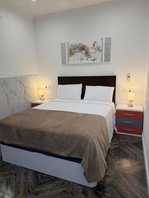 a bedroom with a large bed with two night stands at HAVELI Vinaros in Vinarós