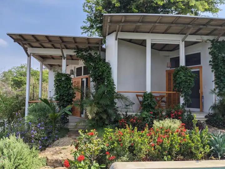 a house with a bunch of flowers in front of it at Poolside Cabaña Studio with stunning ocean view in Puerto Escondido