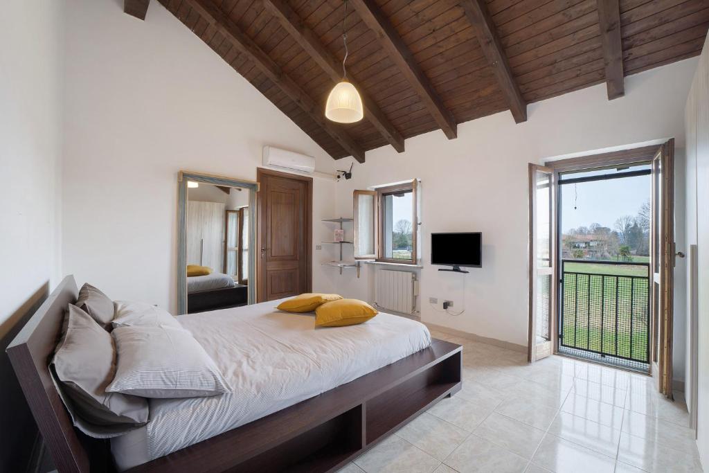 a bedroom with a large bed and a television at La mansarda di Mariuccia in Castelletto sopra Ticino