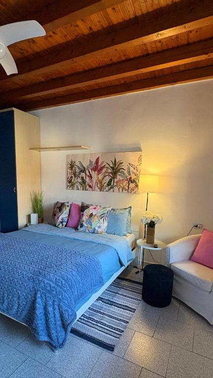 a bedroom with a large bed and a couch at La casetta in Cesano Maderno