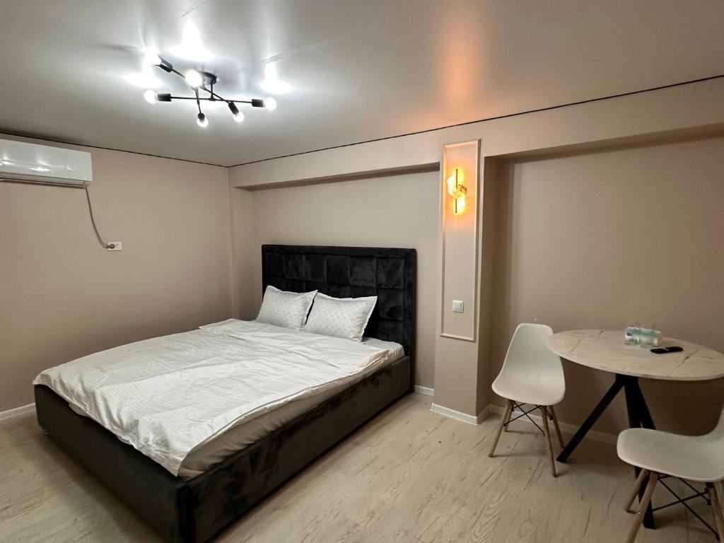 a bedroom with a bed and a table and chairs at Meridian Hotel in Almaty