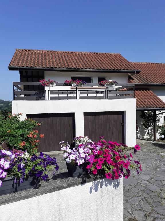 a house with two garage doors and some flowers at Sérénité in Jussac