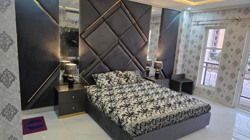 a bedroom with a bed with a large headboard at Skyline Central Apartments in Islamabad