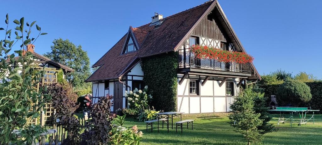 a large house with flowers on the side of it at Dabki Village - Villa Rena in Dąbki