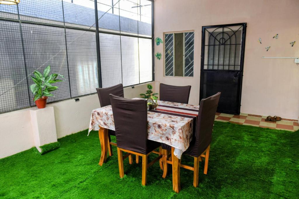 a table and chairs in a room with green grass at Aura attic residency in Bangalore