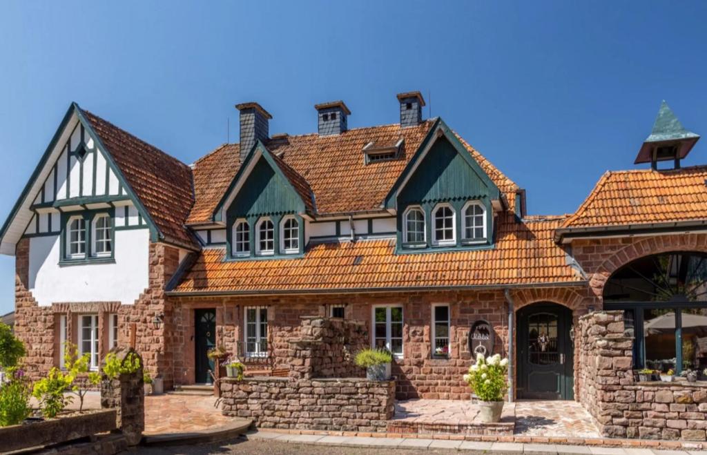 an old house with an orange roof at Wildblick Appartment Hof Grindelborn in Mürlenbach