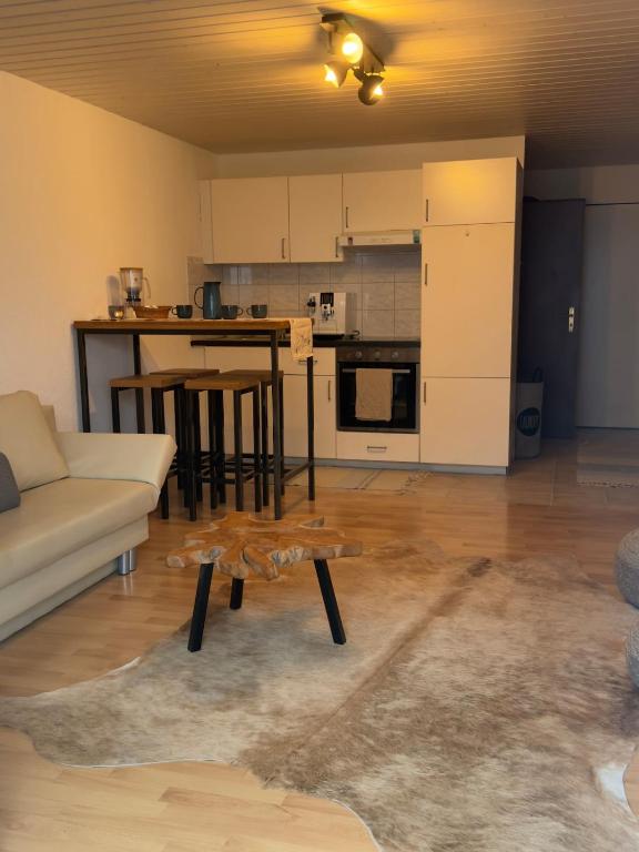 a living room with a couch and a table at Ruhiges Apartment am See in Altnau