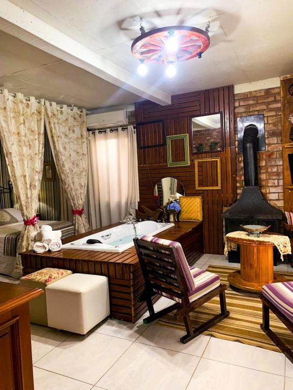 a bedroom with a large bed and a fireplace at Cabana Refúgio do Recanto in São Valentim do Sul