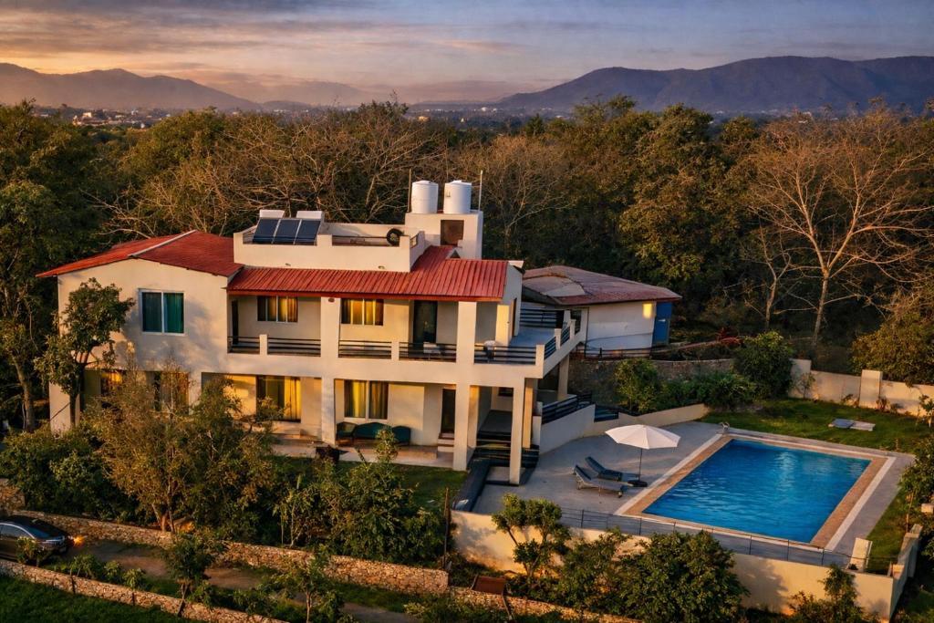 an aerial view of a house with a swimming pool at The Jungle Gate Villa in Udaipur