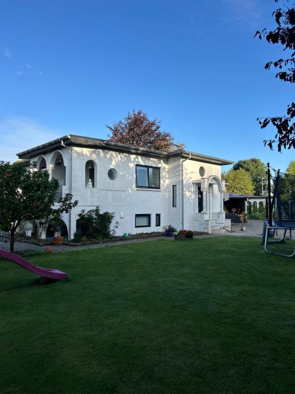 a white house with a playground in the yard at Sweet Home in Aarhus