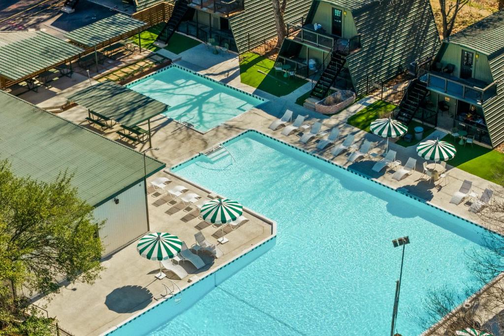 an overhead view of a swimming pool with chairs and umbrellas at Petit Cowboy in New Braunfels