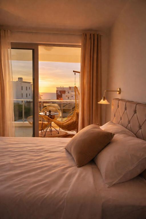 a bedroom with a bed with a view of a balcony at NUR Apartment in Dobra Voda
