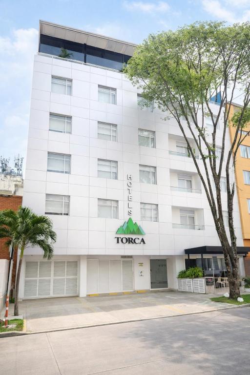 a white building with a tago sign on it at Torca Hotel in Cali