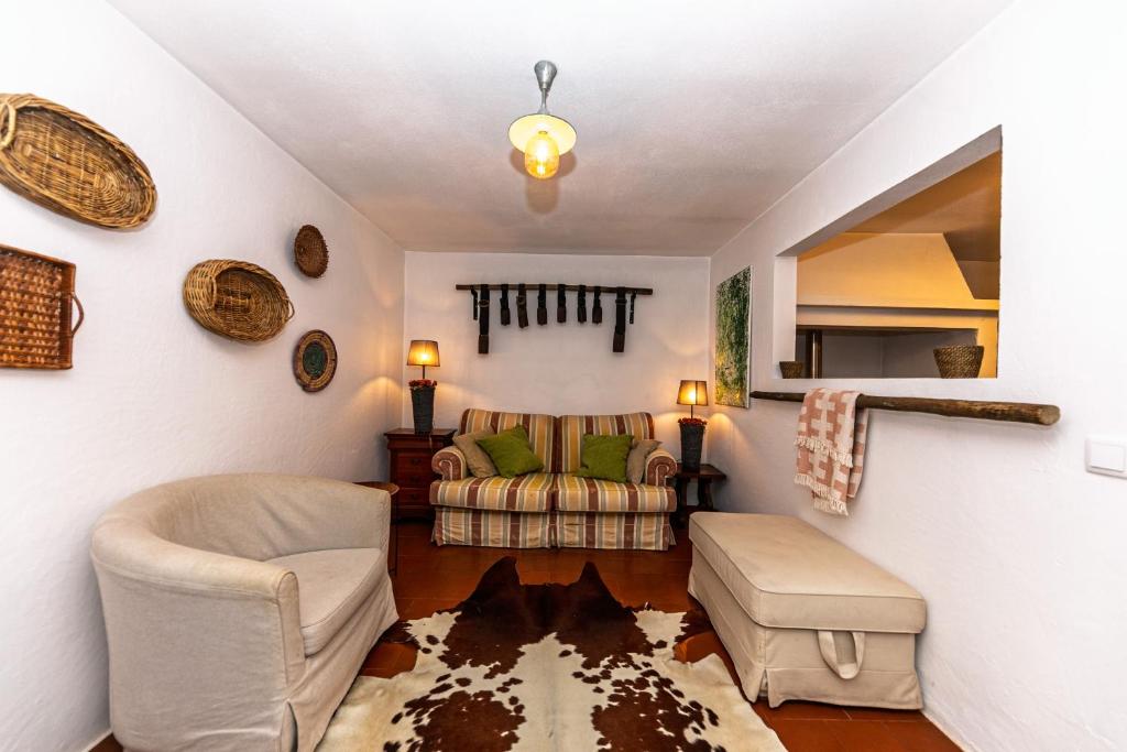 a living room with two chairs and a couch at Cá Ficamos - T1 Hortacasa Portugal in Santiago do Cacém