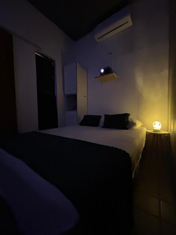 a bedroom with a bed in a dark room at Suíte Neblina in Garanhuns