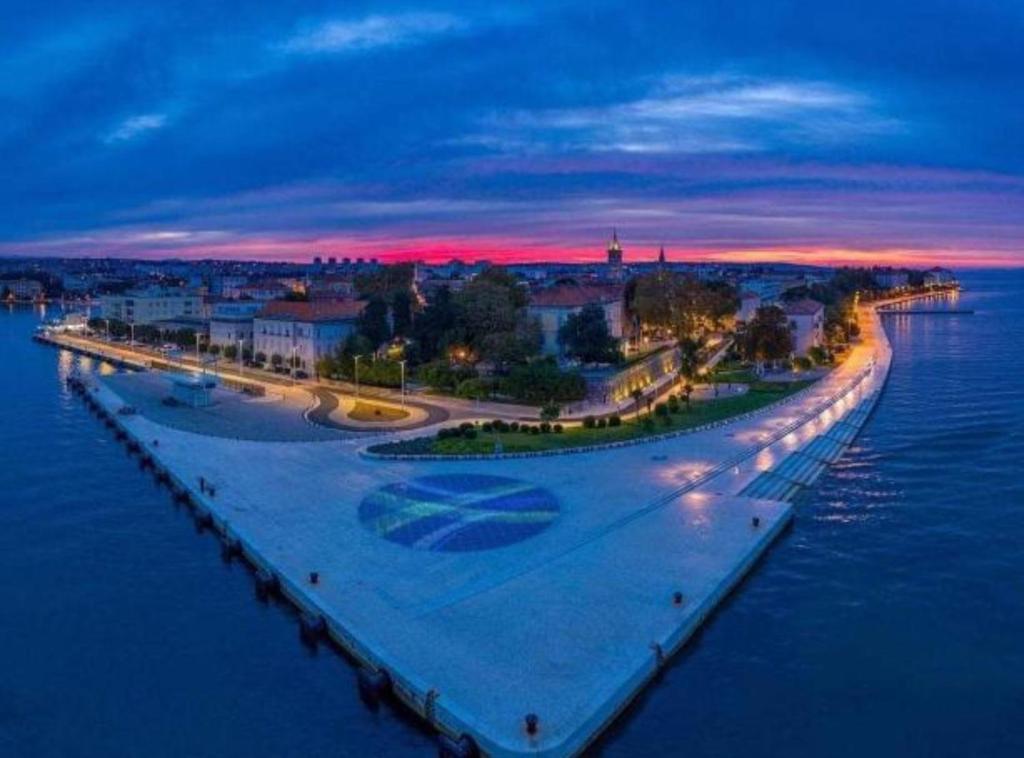 a bridge over a body of water at night at Holiday House Franov in Zadar