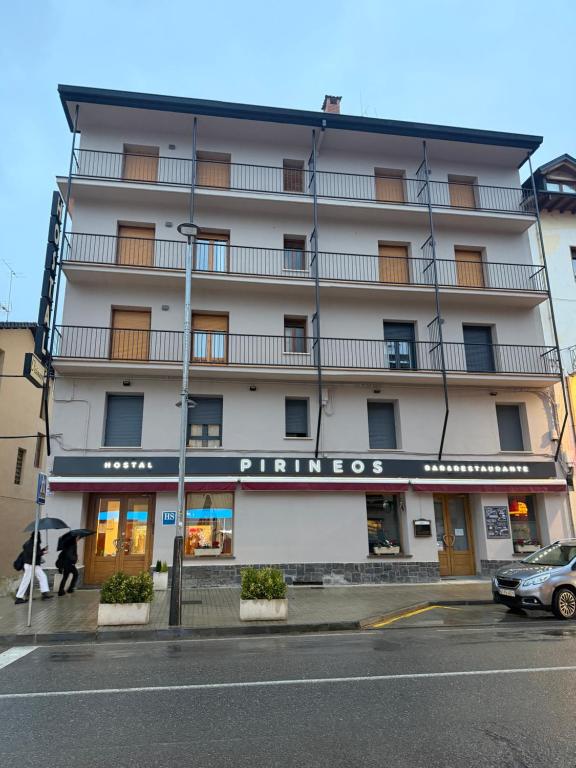 a large white building with a sign that reads primos at Hotel Pirineos Ainsa in Aínsa