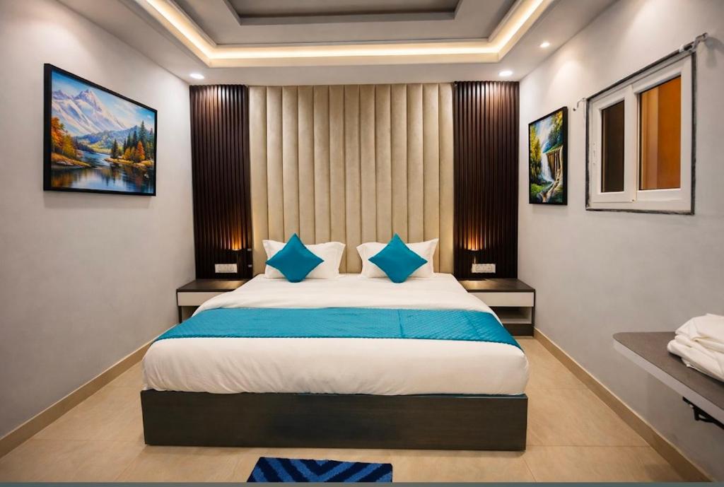 a bedroom with a large bed with blue pillows at The Nest Kashi in Varanasi