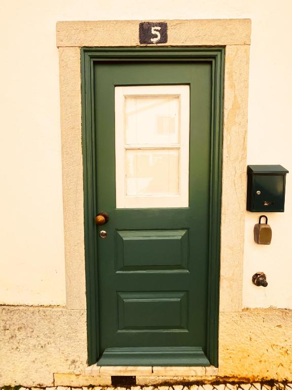 a green door with a number five on it at Cascais Little Garden Rooms Old Town in Cascais