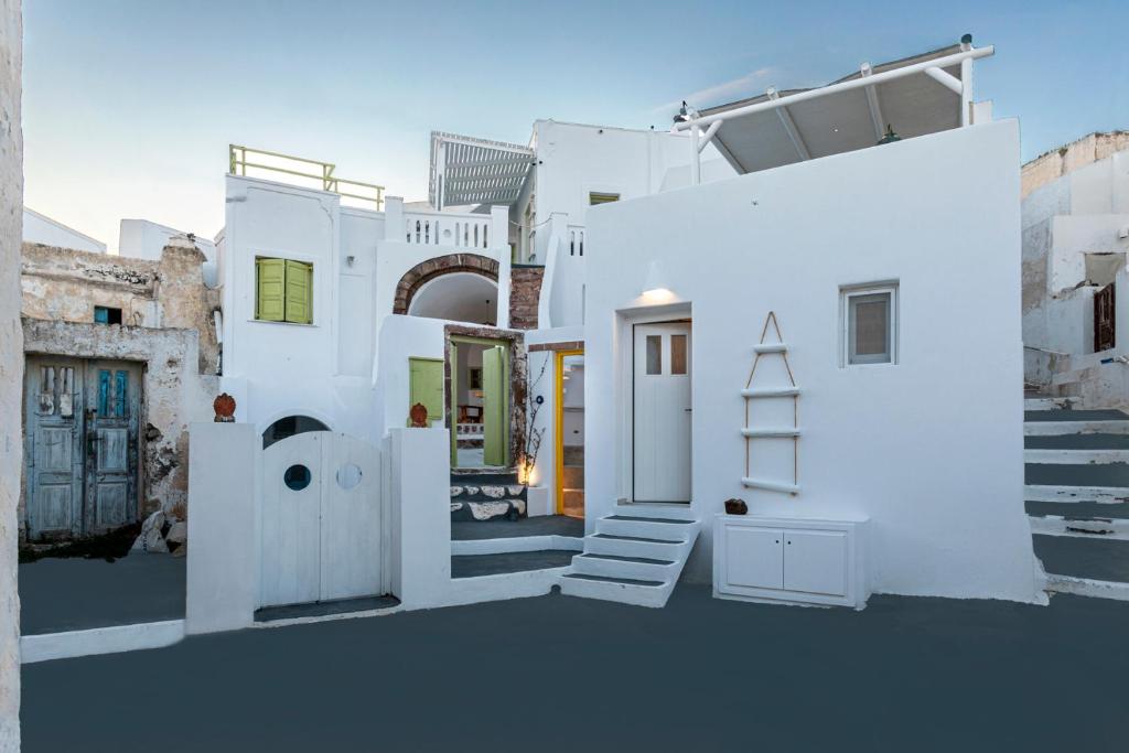 a white house with a staircase in front of it at Casa Grande Santorini in Megalochori