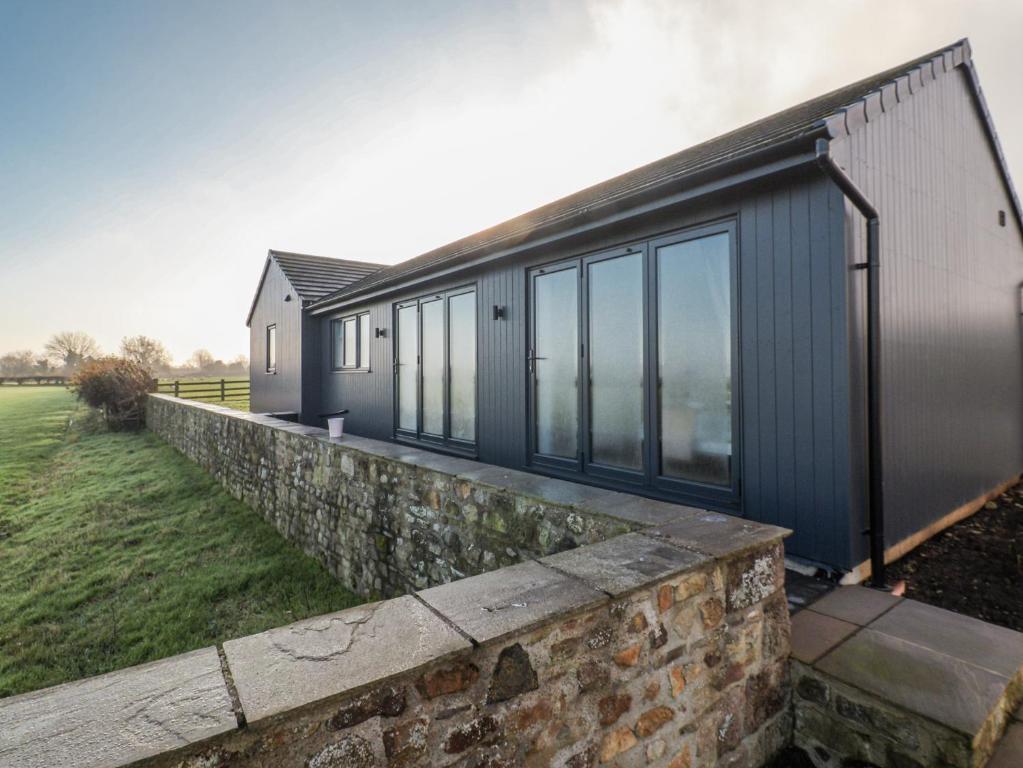 a house with a stone retaining wall and windows at Genesis in Richmond