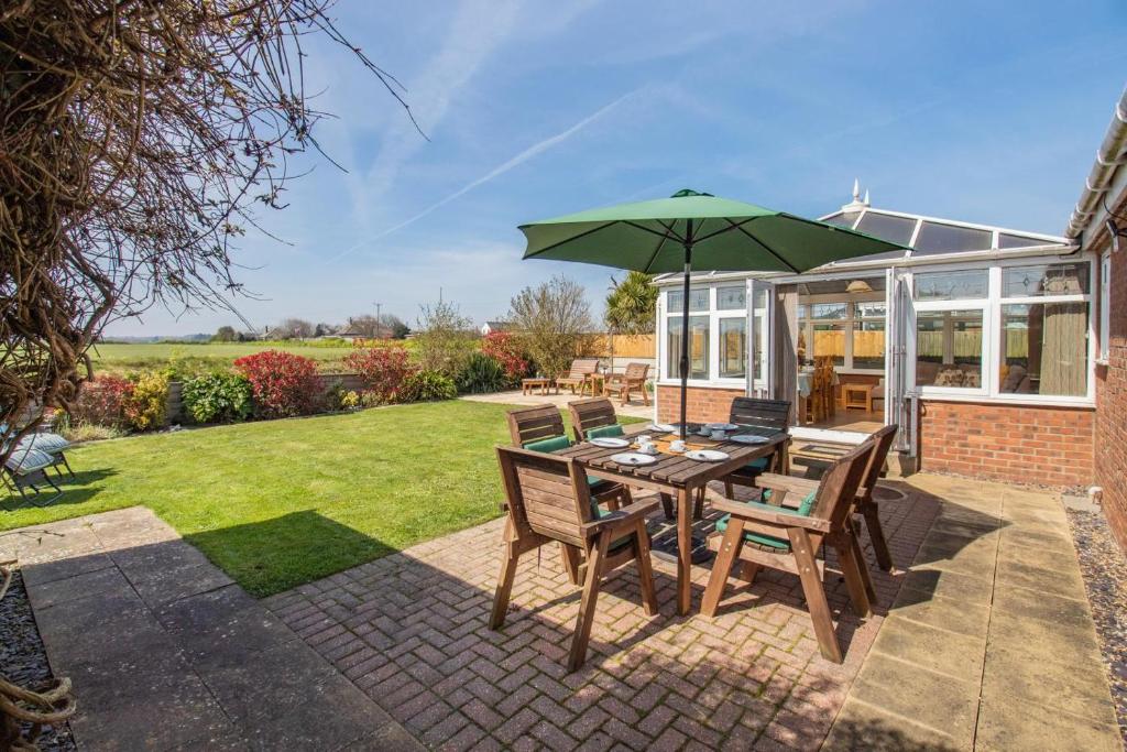 a patio with a table with a green umbrella at 3 Bed in Walcott oc-2135 in Walcott