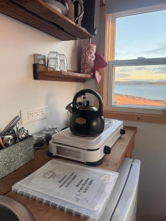 a tea kettle sitting on top of a kitchen counter at Les Cabanes du Cap in Miquelon