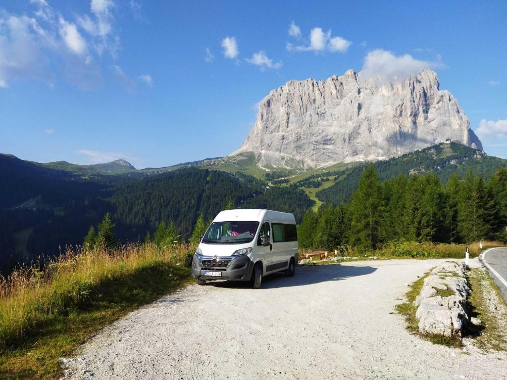 a van parked on a road in front of a mountain at Kampervan in Vrhovine