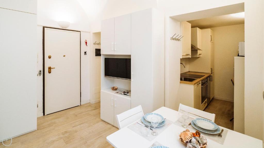 a white apartment with a table and a kitchen at XX Settembre 68 in Alassio
