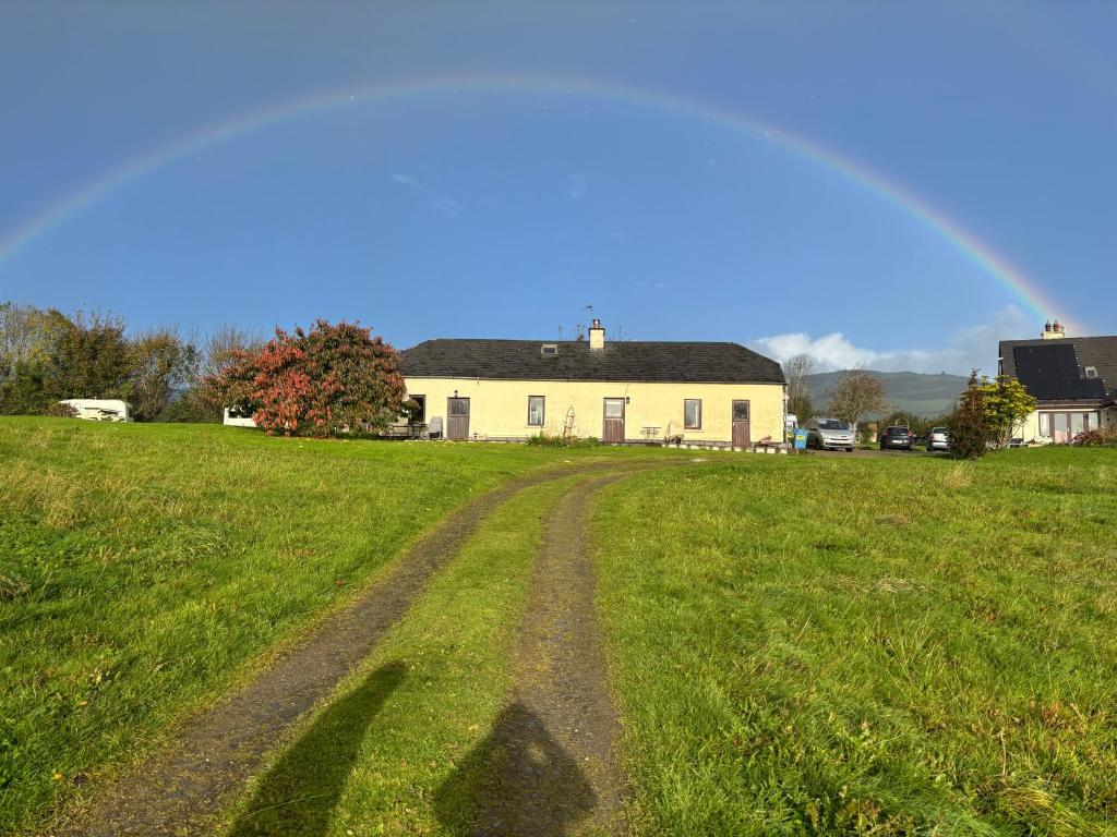 a dirt road in a field with a house at Deerpark Holiday Cottage (1) in Killaloe