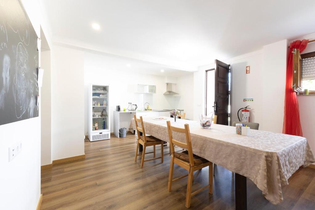 a kitchen and dining room with a table and chairs at Trajadinha do Lima Rooms in Ponte de Lima